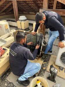 Two AC technicians working on AC