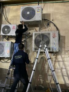 Two AC technicians installing Air Conditioners